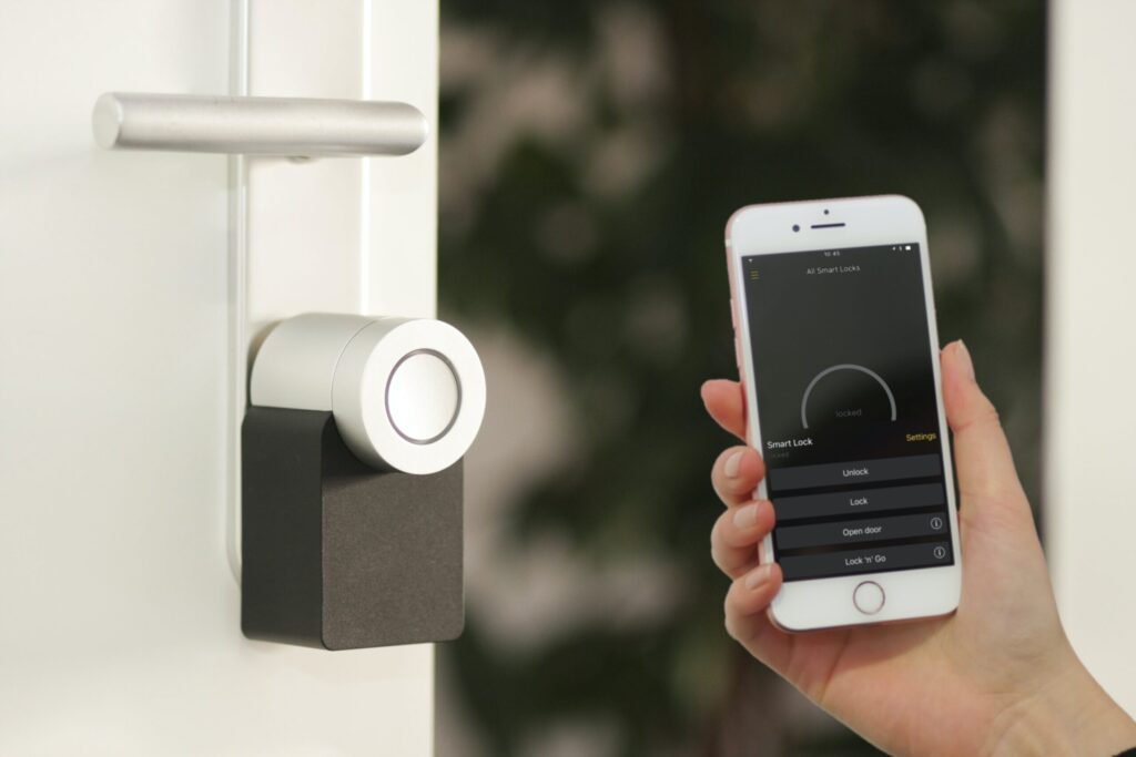 person holding phone with smart lock home security
