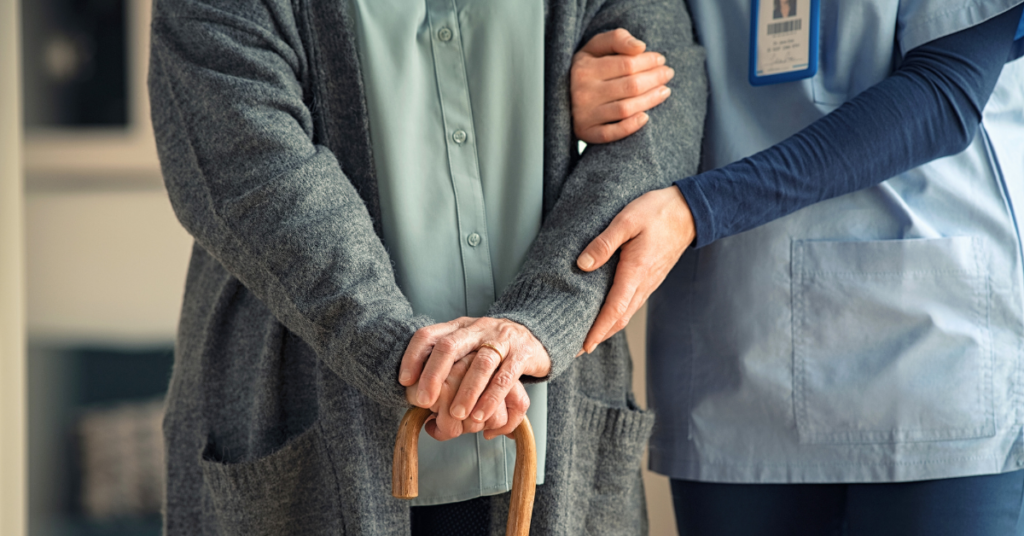 nurse walking with an elderly woman at a senior living facility