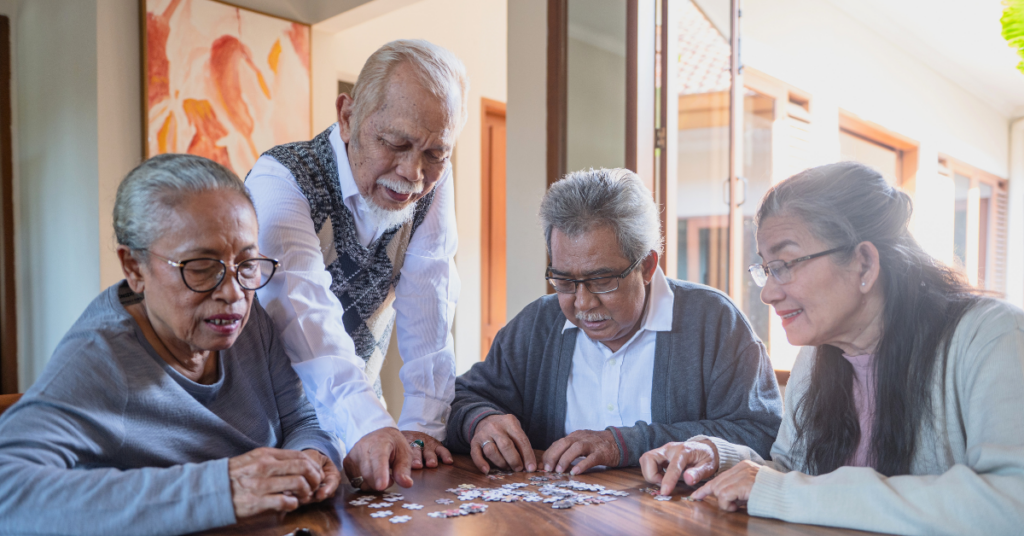Residents of a senior living facility doing a puzzle
